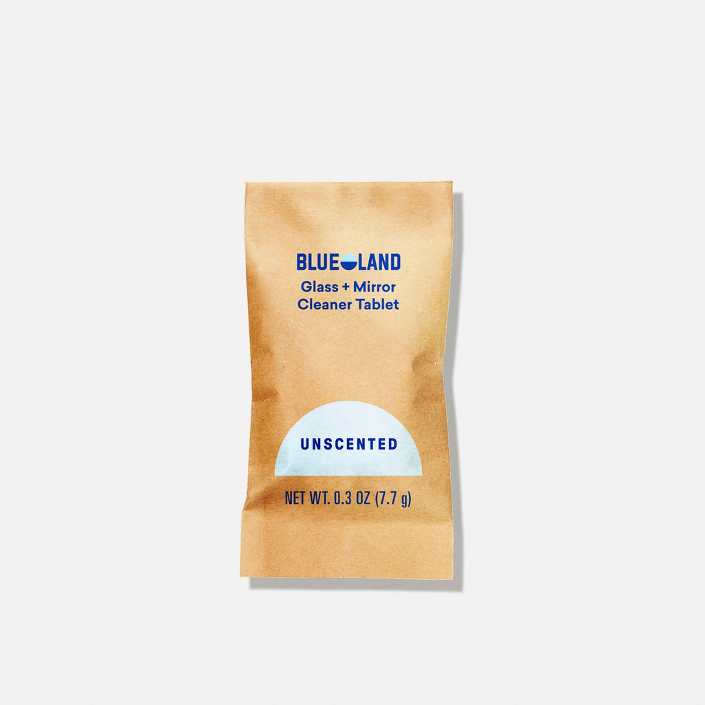 A brown packet labeled BLUELAND Glass + Mirror Cleaner Tablet, Unscented, Net Wt. 0.3 oz (7.7 g) on a plain white background.